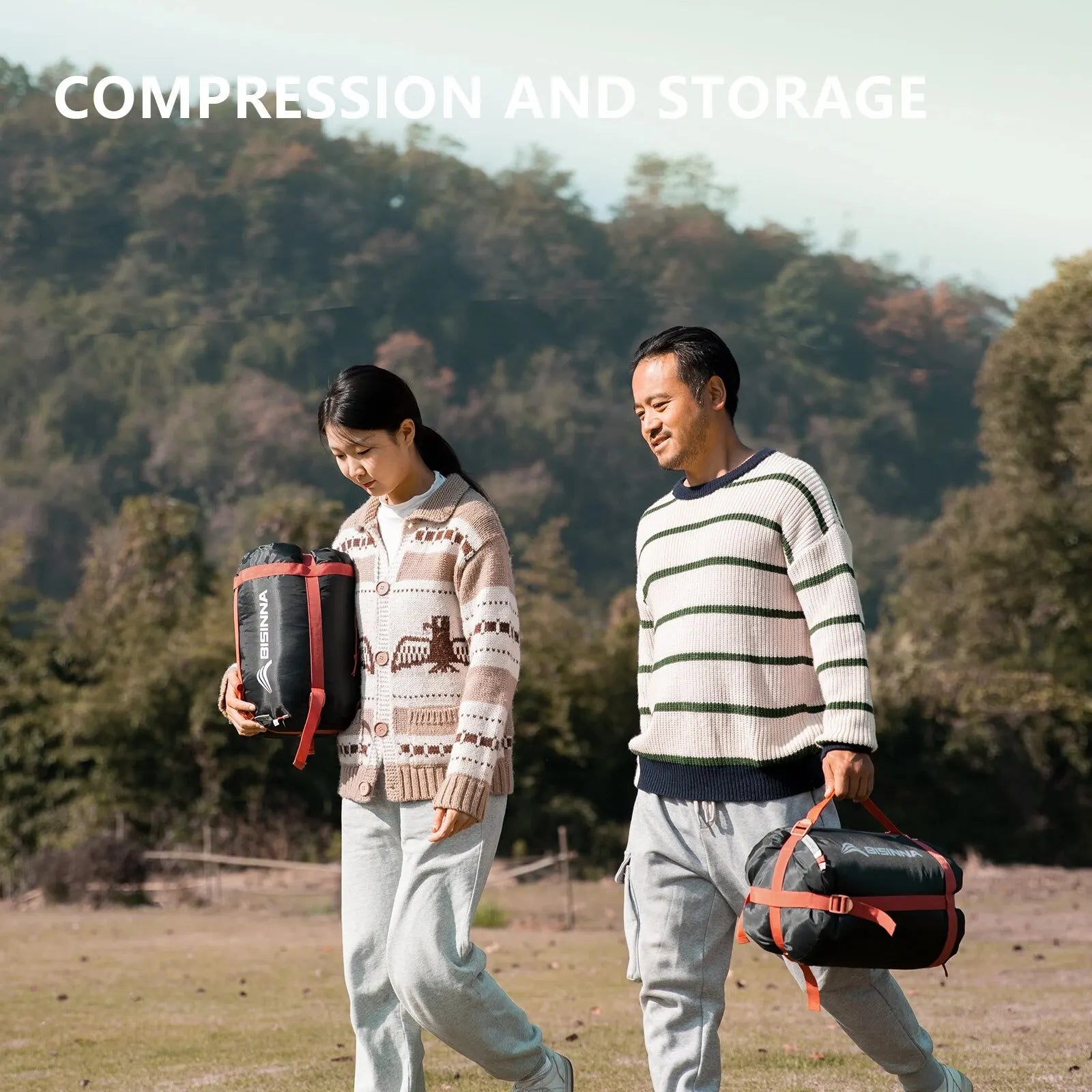 Two people walking outdoors with BISINNA compression bags, surrounded by trees.
