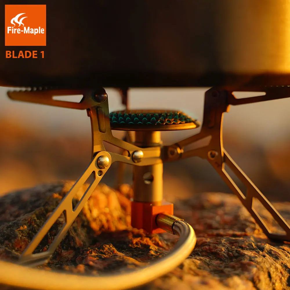 Fire-Maple camping stove on a natural background with 'Fire-Maple' branding.