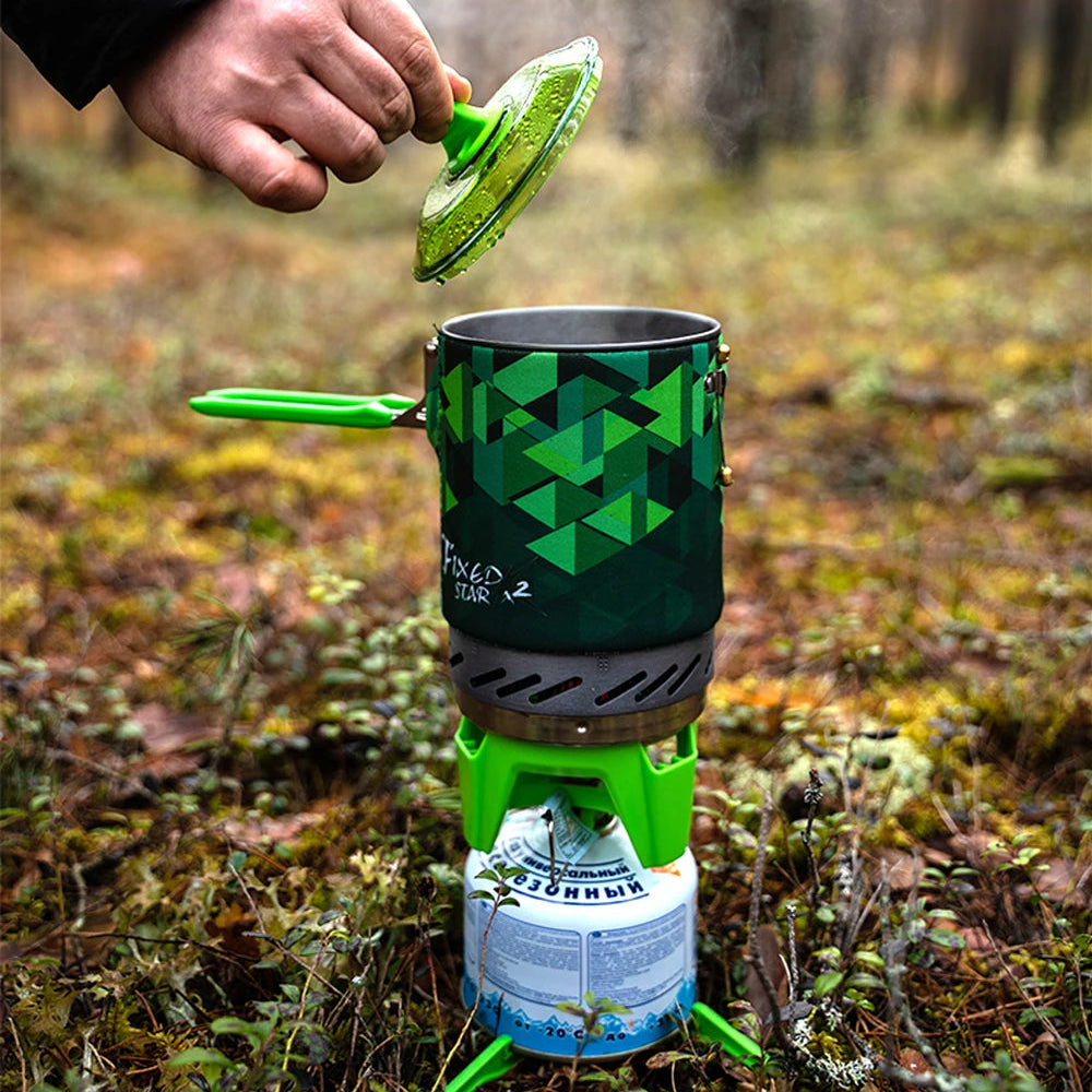 Portable FMS-X2 camping stove with green geometric design in a forest setting