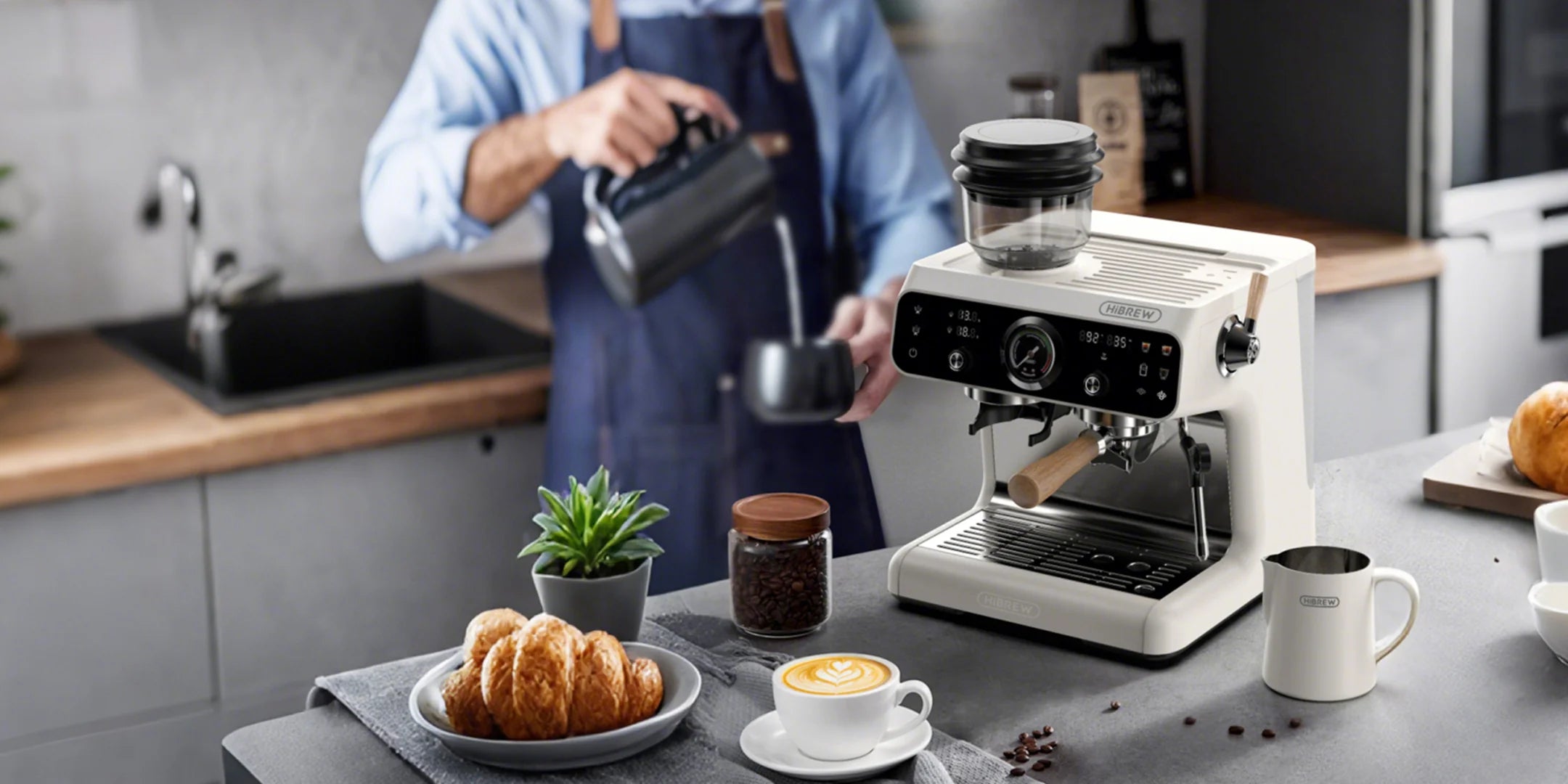 Person making coffee using a white Hibrew espresso machine in a kitchen.
