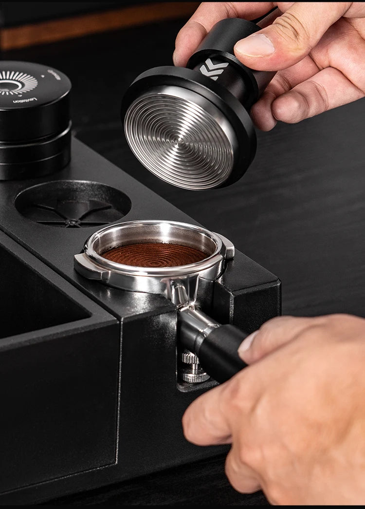 Person using a IKAPE coffee tamper.