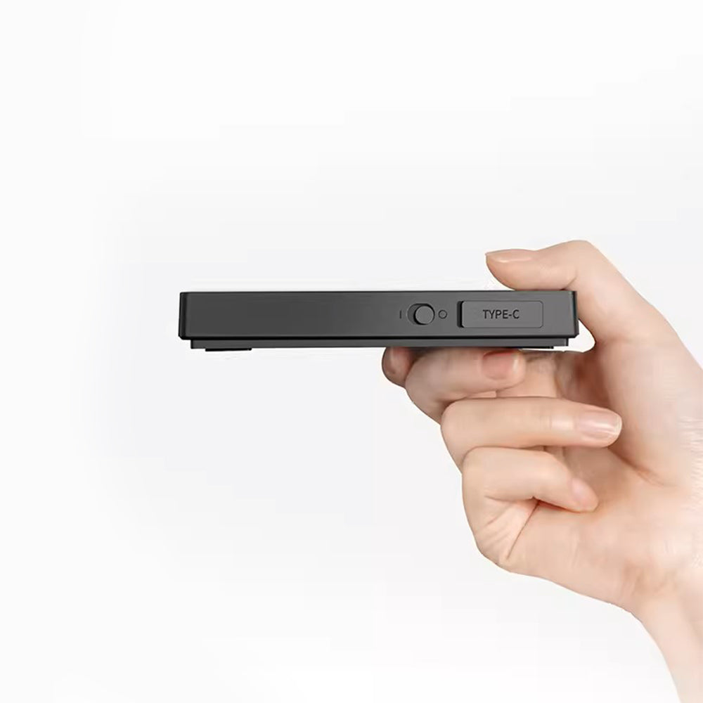 Hand holding a black electronic device with 'Type-C' label on a white. background