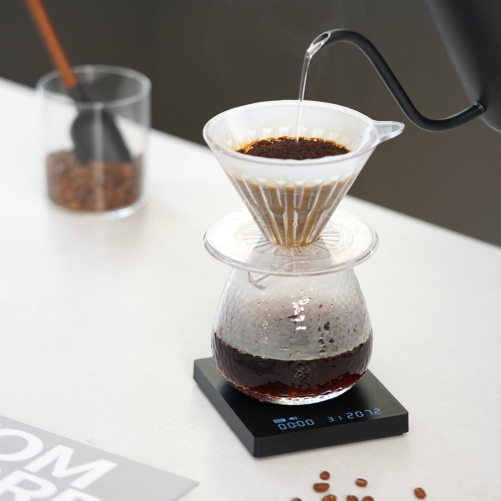 Coffee brewing process with a pour-over setup on a TIMEMORE Black Mirror Mini digital coffee scale.