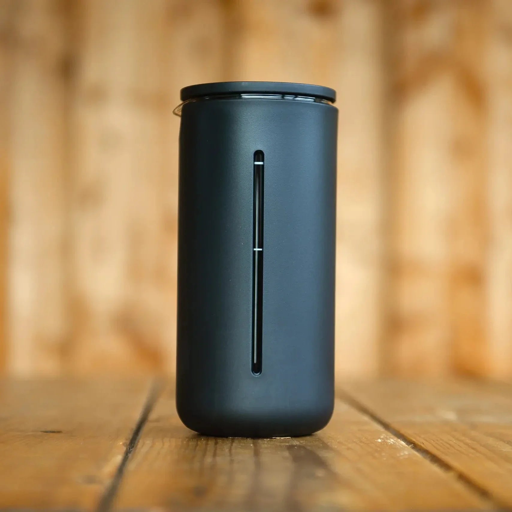 Black TIMEMORE U French Press on a wooden surface with a blurred wooden background