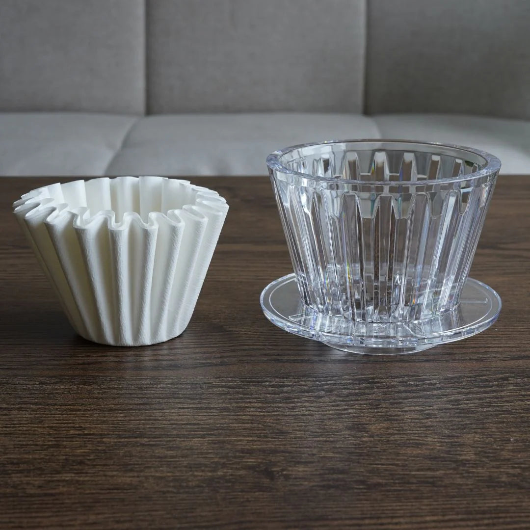 Close up shot featuring a TIMEMORE B75 dripper and the compatible filter paper aside each other 