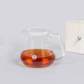 Clear TIMEMORE Borosilicate Glass teapot with amber liquid on a light gray background
