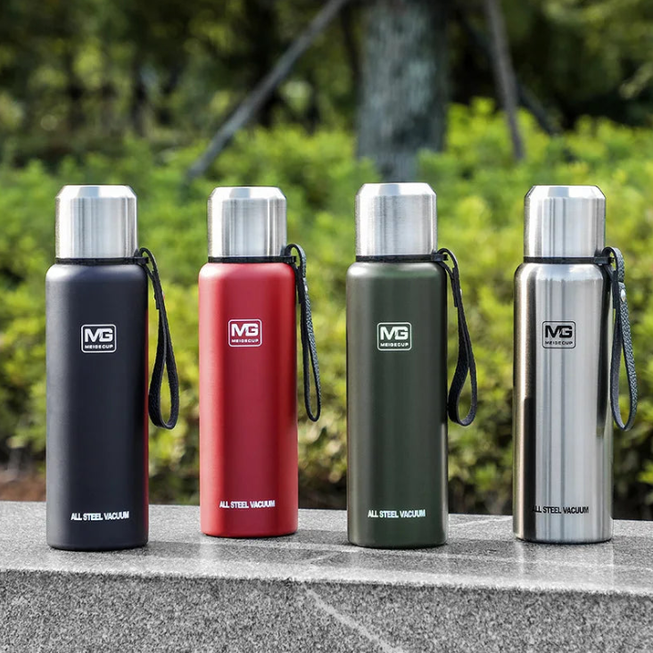 Four insulated bottles in black, red, green, and silver with visible MG logo on a blurred natural background.